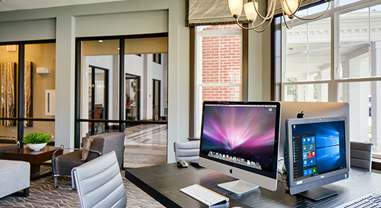 Computers & monitors on a desk in a conference room. One of the topnotch services offered at Enclave at Box Hill.